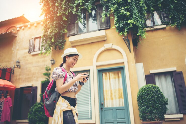Foto gratuito retrato de la mochila joven de la mujer del inconformista que viaja tomando la foto en urbano.