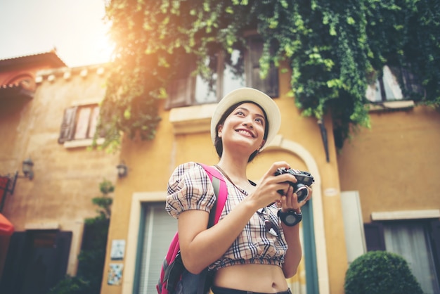 Retrato de la mochila joven de la mujer del inconformista que viaja tomando la foto en urbano.