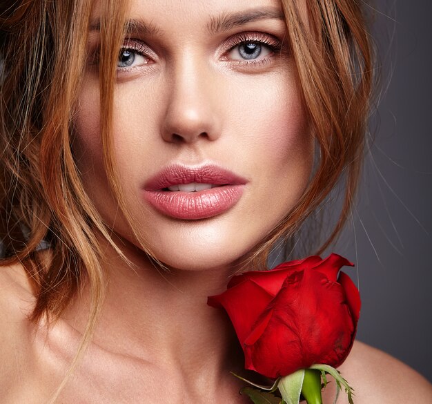 Retrato de moda de belleza de joven rubia modelo con maquillaje natural y piel perfecta con hermosa rosa posando