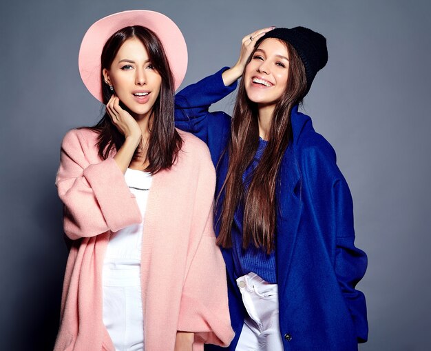 Retrato de moda de dos sonrientes modelos de mujeres morenas en verano casual hipster abrigo posando