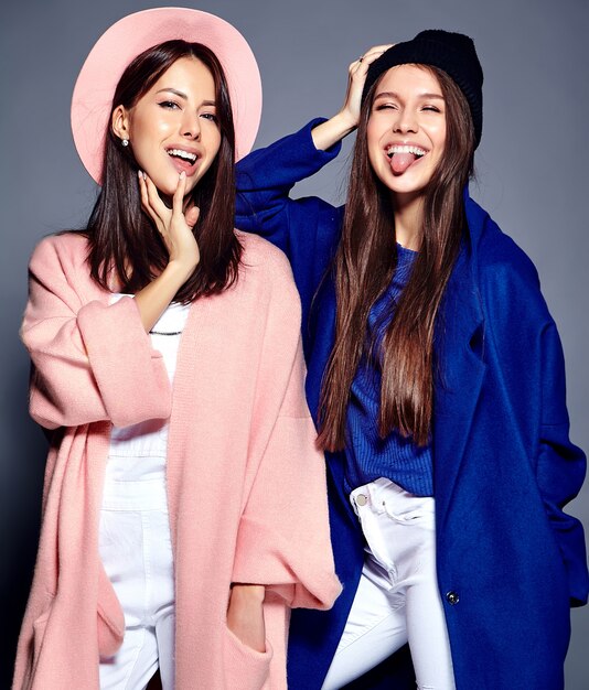 Retrato de moda de dos sonrientes modelos de mujeres morenas en verano casual hipster abrigo posando