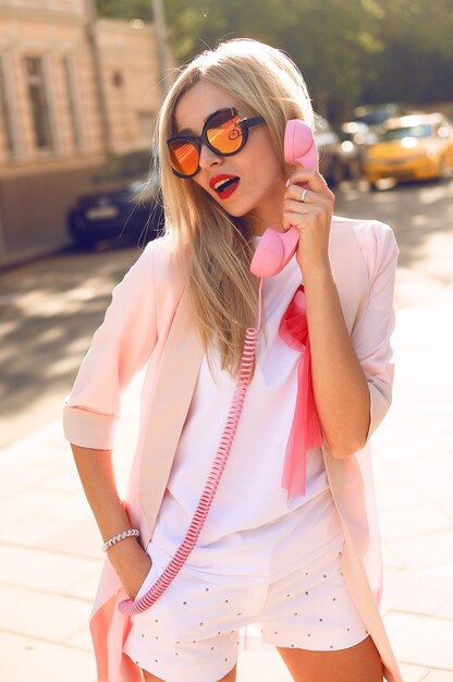 Retrato de moda de estilo de vida soleado de verano de joven elegante hipster mujer caminando en la calle, vistiendo lindo traje de moda,
