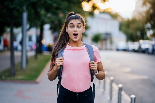 Retrato de moda de estilo de vida de verano de joven sorprendida caminando en la calle