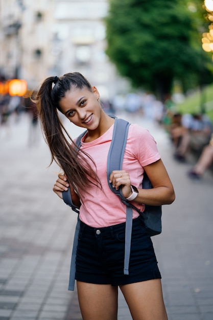 Retrato de moda de estilo de vida de verano de mujer joven inconformista con estilo caminando en la calle