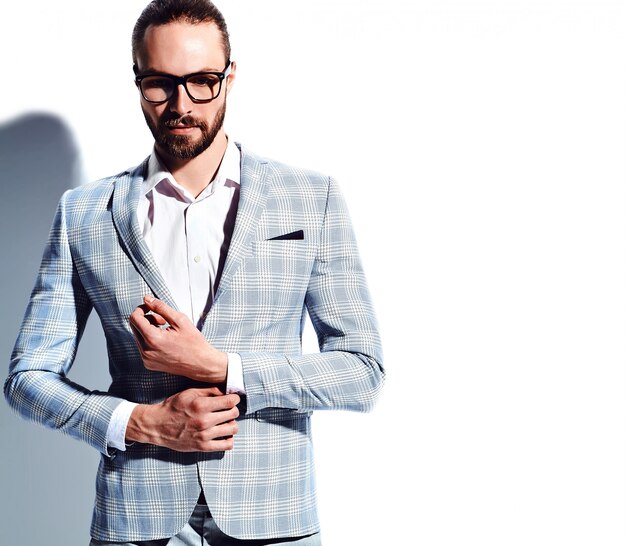 Retrato de moda guapo elegante hipster empresario modelo vestido con elegante traje azul claro en gafas en blanco.