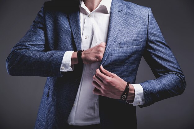 Retrato de moda guapo elegante hipster empresario modelo vestido con elegante traje azul sobre gris