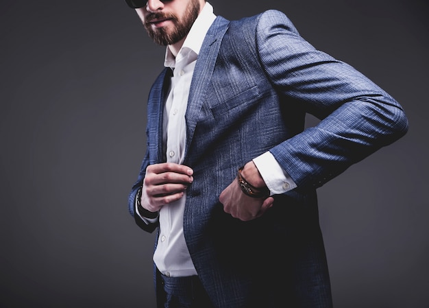 Retrato de moda guapo elegante hipster empresario modelo vestido con elegante traje azul sobre gris