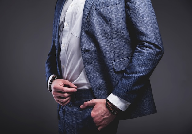 Retrato de moda guapo elegante hipster empresario modelo vestido con elegante traje azul sobre gris
