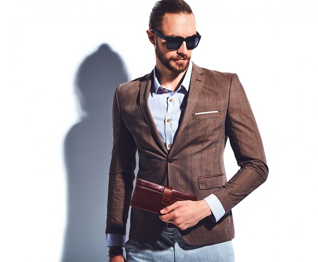 Retrato de moda guapo elegante hipster empresario modelo vestido con elegante traje marrón con gafas de sol