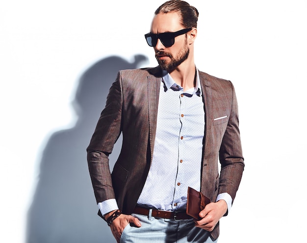 Retrato de moda guapo elegante hipster empresario modelo vestido con elegante traje marrón con gafas de sol