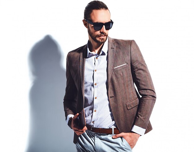 Retrato de moda guapo elegante hipster empresario modelo vestido con elegante traje marrón con gafas de sol