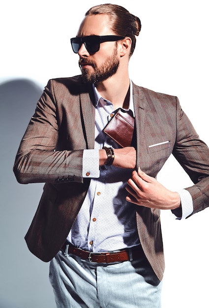 Foto gratuita retrato de moda guapo elegante hipster empresario modelo vestido con elegante traje marrón con gafas de sol