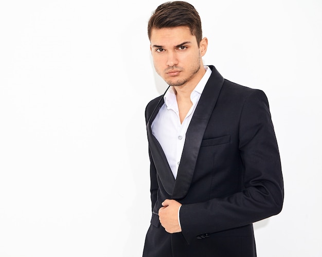 Retrato de moda guapo empresario elegante modelo vestido con elegante traje clásico negro posando. Metrosexual