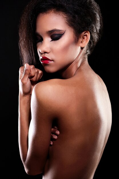 Retrato de moda de la hermosa modelo de chica morena mujer negra americana con maquillaje brillante labios rojos espalda desnuda.