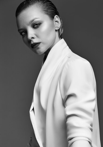 Retrato de moda hermosa mujer morena elegante modelo con maquillaje de noche y labios rojos en chaqueta blanca