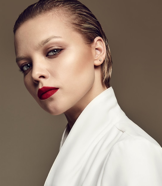 Retrato de moda hermosa mujer morena elegante modelo con maquillaje de noche y labios rojos en chaqueta blanca