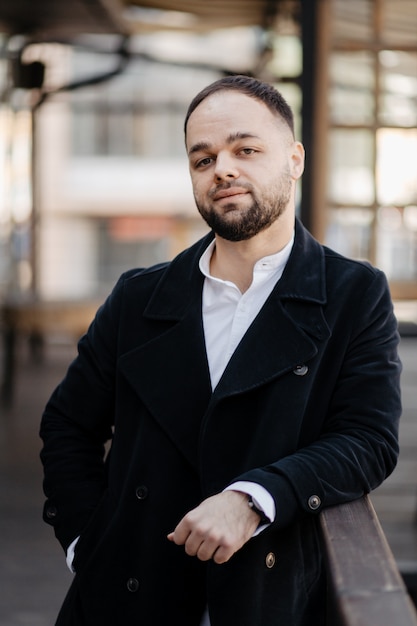 Foto gratuita retrato de moda hombre bien vestido con barba posando al aire libre