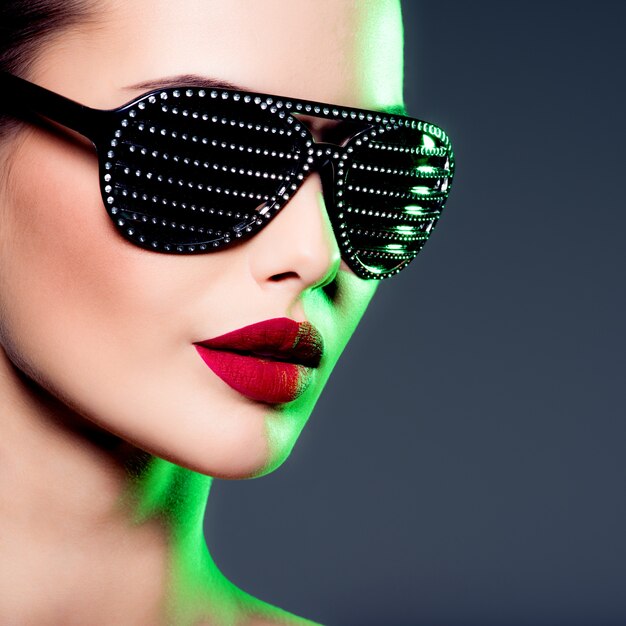 Retrato de moda de mujer con gafas de sol negras con diamantes. Colores saturados