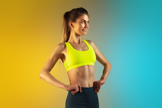 Retrato de moda de mujer joven en forma y deportiva sobre fondo degradado. Cuerpo perfecto listo para el verano.