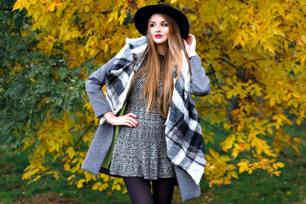 Retrato de moda de otoño de mujer elegante glamour posando en el increíble parque de la ciudad, elegante abrigo, mochila y sombrero vintage. Caminando solo, clima frío