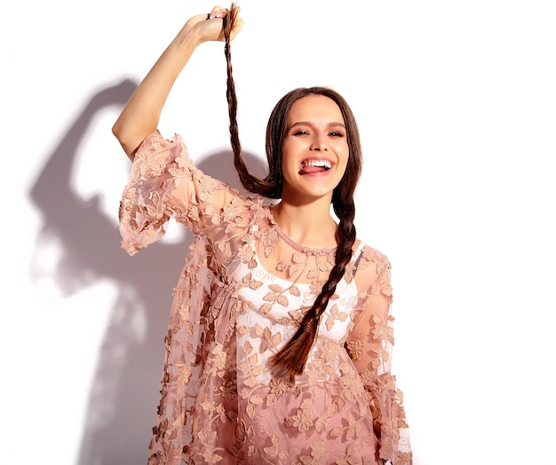 Retrato del modelo caucásico sonriente de la mujer morena hermosa en la ropa elegante del verano rosado brillante aislada en el fondo blanco.