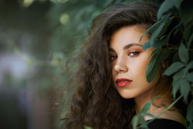 Retrato de modelo confiado entre hojas de parra