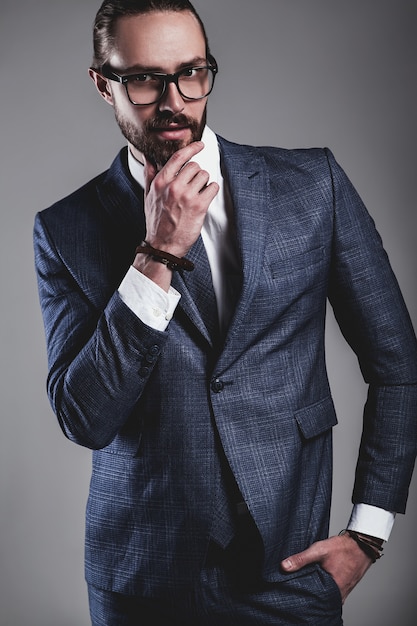 Foto gratuita retrato del modelo de empresario de moda guapo vestido con elegante traje azul con gafas