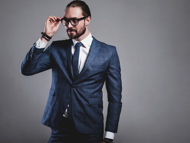 Foto gratuita retrato del modelo de empresario de moda guapo vestido con elegante traje azul con gafas