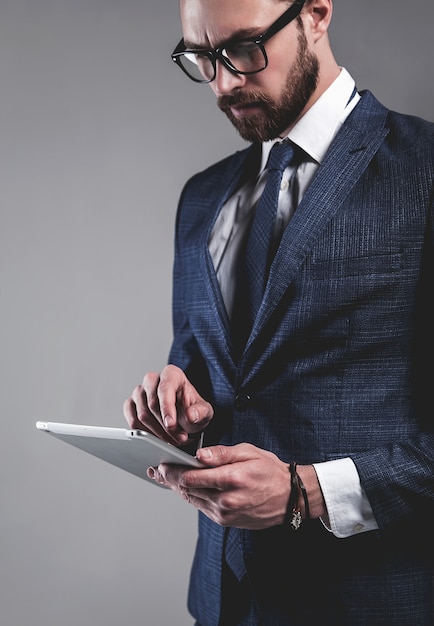 Foto gratuita retrato del modelo de empresario de moda guapo vestido con elegante traje azul con gafas