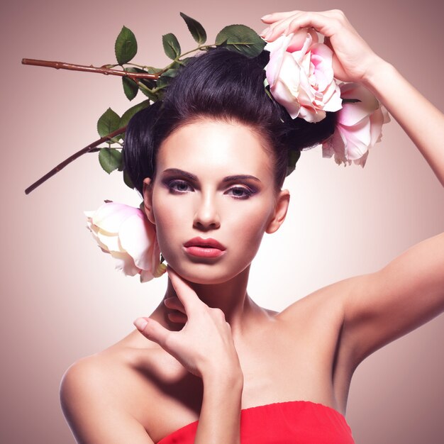 Retrato de modelo con flores rosas en pelos. Estilo de Instagram