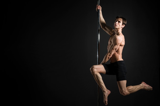 Retrato de modelo masculino realizando un pole dance