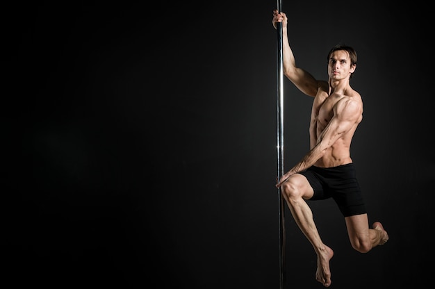 Retrato de modelo masculino realizando un pole dance