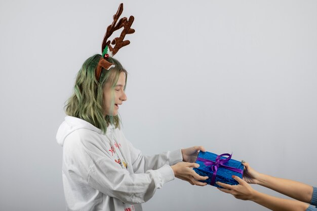 Retrato de un modelo de mujer joven dando un regalo.