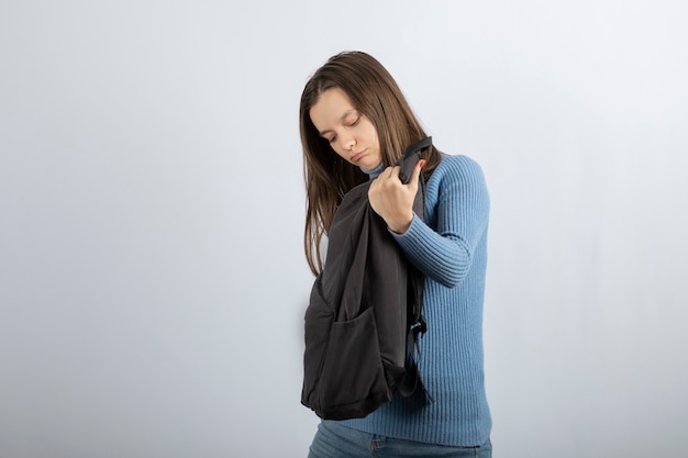 Retrato de un modelo de mujer joven con mochila y posando.