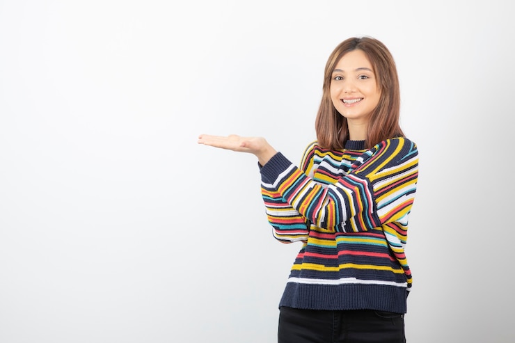 Foto gratuito retrato de un modelo de mujer joven sonriente que muestra las palmas abiertas.