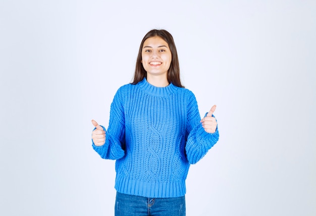 Retrato de un modelo de niña sonriente mostrando los pulgares para arriba.