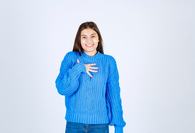 Retrato de un modelo de niña sonriente de pie y mirando hacia adelante.