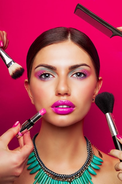 Retrato de modelo con piel perfecta, maquillaje brillante, grandes labios rosados y collar