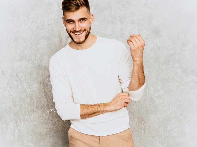 Retrato del modelo sonriente hermoso del hombre de negocios del inconformista que lleva la ropa blanca casual del verano.