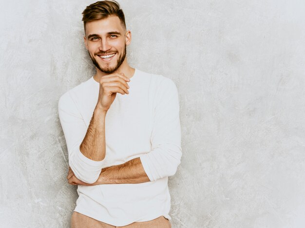 Retrato del modelo sonriente hermoso del hombre de negocios del inconformista que lleva la ropa blanca casual del verano.