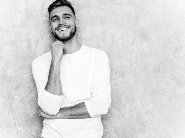 Retrato del modelo sonriente hermoso del hombre de negocios del inconformista que lleva la ropa blanca casual del verano.