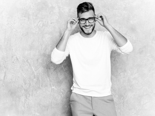 Retrato del modelo sonriente hermoso del hombre de negocios del inconformista que lleva la ropa blanca casual del verano.