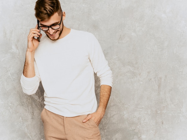 Retrato del modelo sonriente hermoso del hombre de negocios del inconformista que lleva la ropa blanca casual del verano.