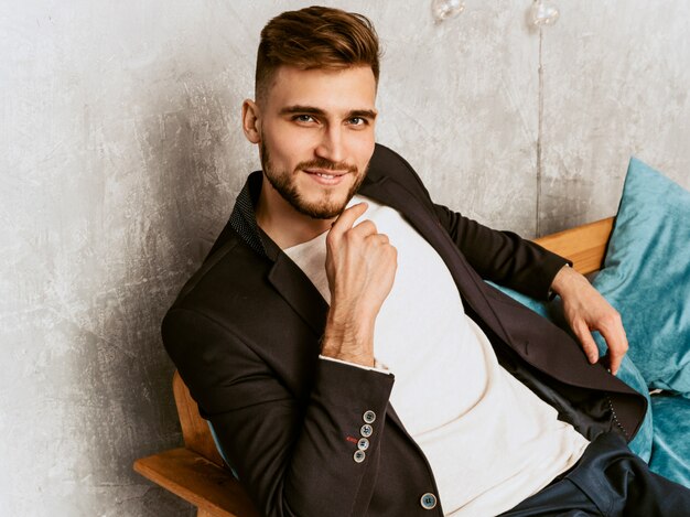 Retrato del modelo sonriente hermoso del hombre de negocios del inconformista que lleva el traje negro casual.