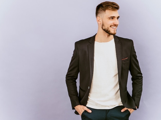 Retrato del modelo sonriente hermoso del hombre de negocios del inconformista que lleva el traje negro casual.