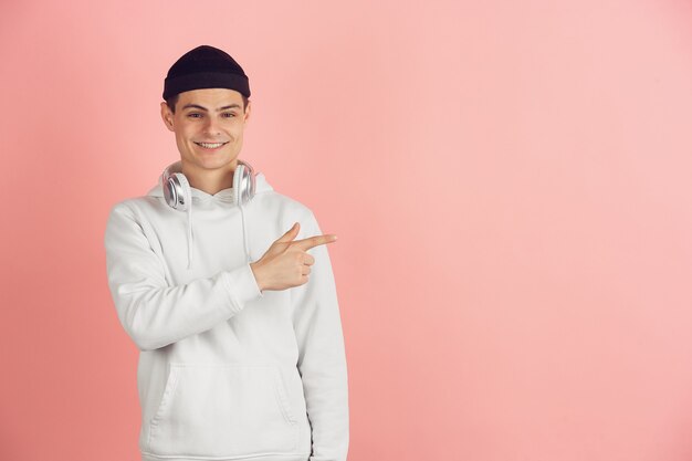 Retrato moderno de joven caucásico en estudio rosa