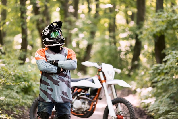 Retrato de motociclista posando en el bosque