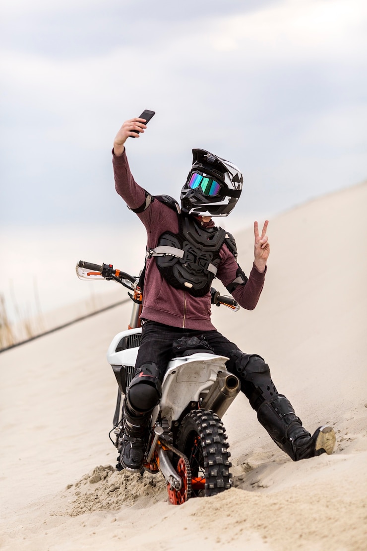 Foto gratuito retrato de motociclista tomando una selfie en el desierto