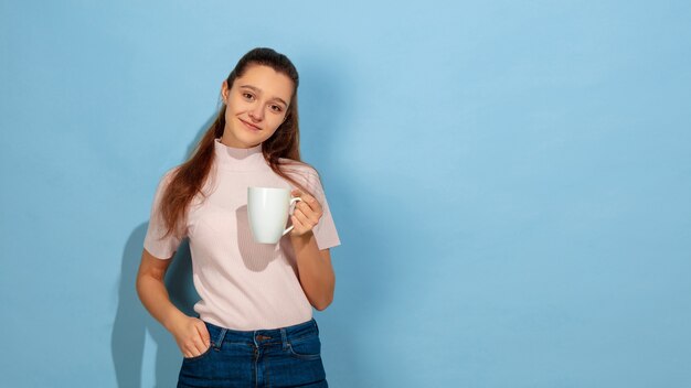 Retrato de muchacha adolescente caucásica aislado en azul