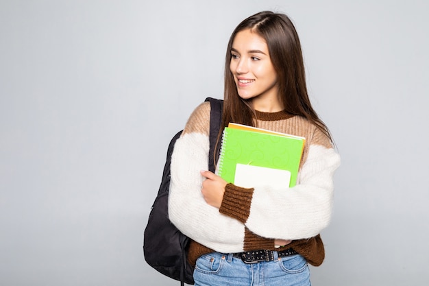 Retrato de muchacha atractiva linda joven estudiante aislada en la pared blanca